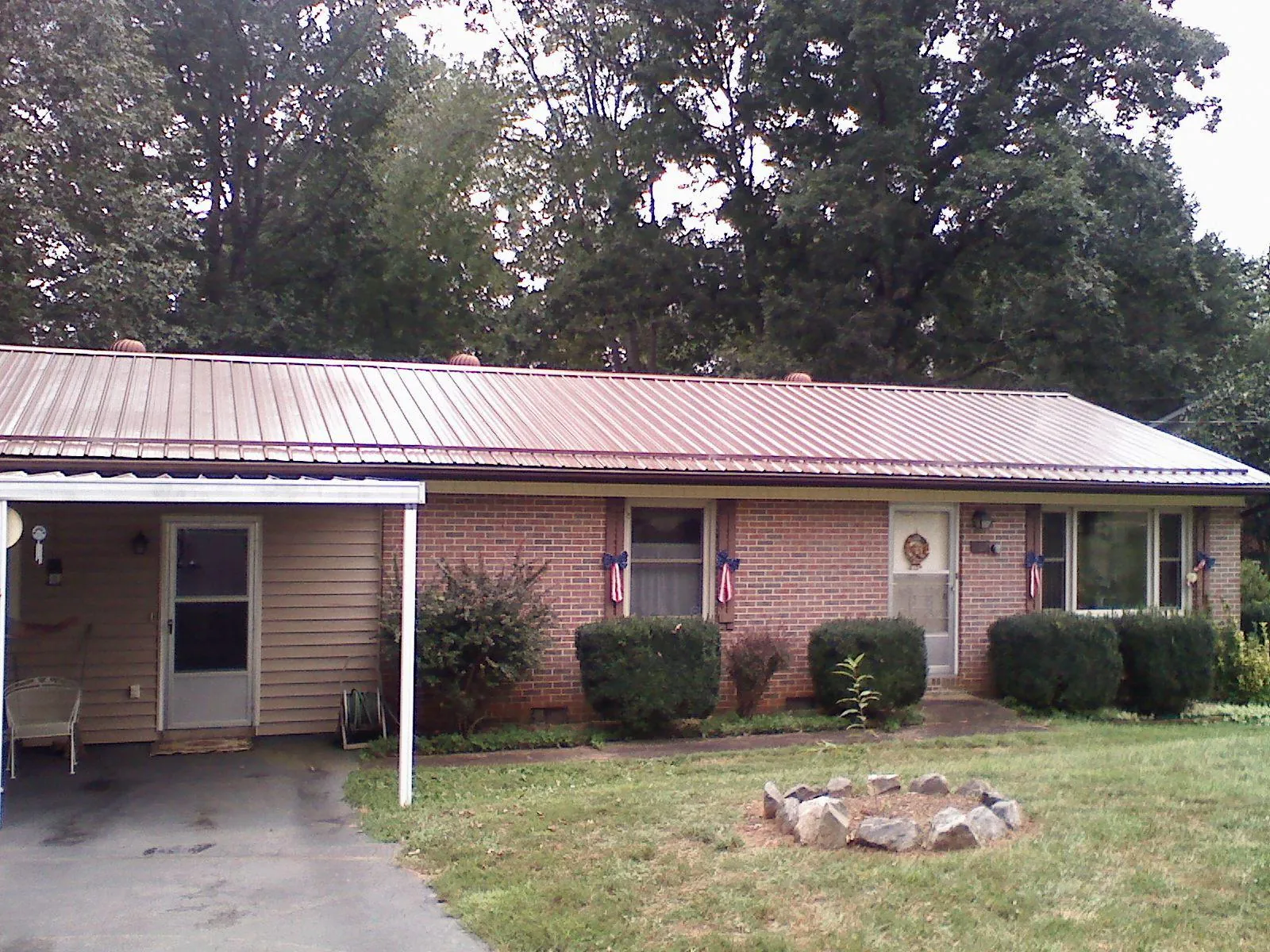 Bronze metal roof and carport on a brick ranch home — Roof Repair work by our crew in Le Roy